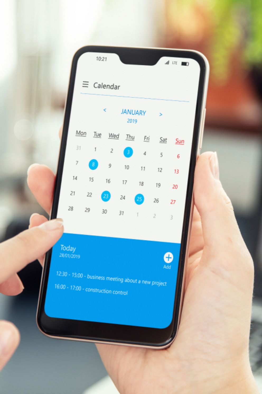 Eine Person überprüft den Kalender auf dem Bildschirm ihres Smartphones