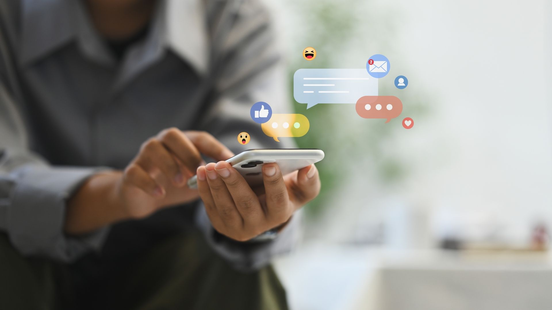 Person hält ein Smartphone, über dem digitale Chat- und Social-Media-Symbole eingeblendet sind.