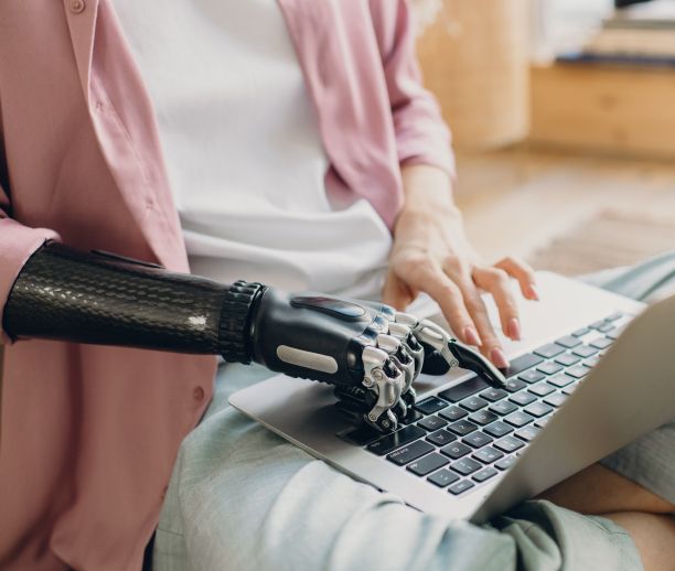 Frau mit Handprothese an Laptop