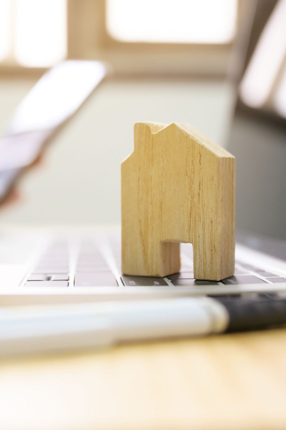 Ein kleines Holzhaus steht auf einem Laptop