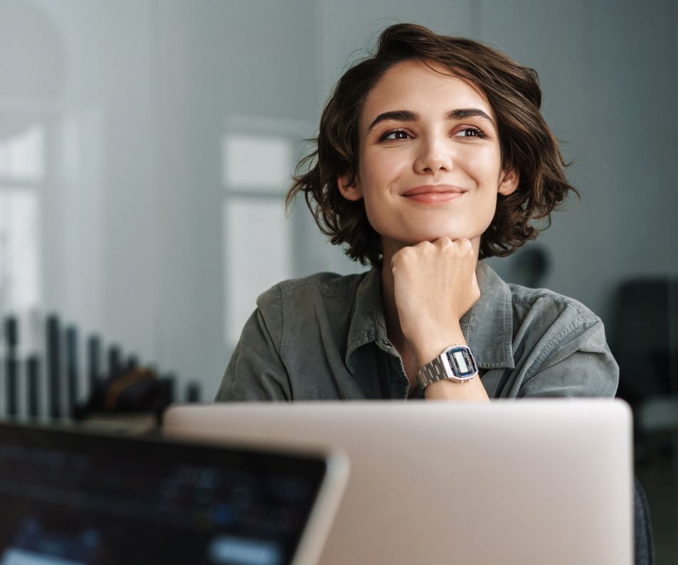 Zufriedene Kundin schaut hinter dem Monitor hervor